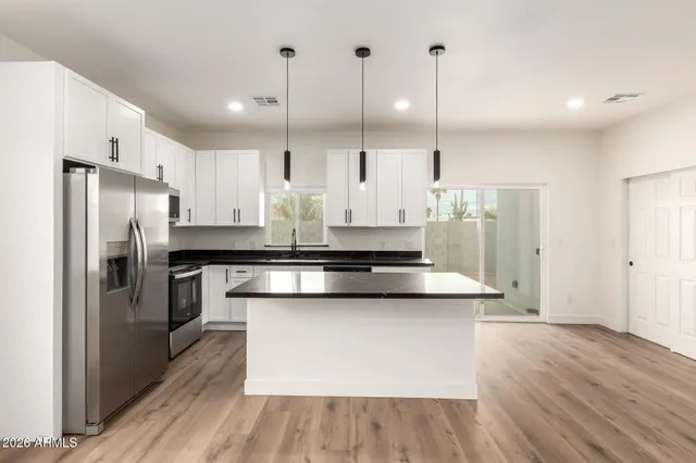 a kitchen with stainless steel appliances kitchen island a refrigerator sink and stove