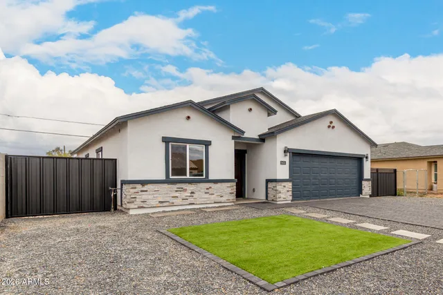 a front view of house with yard and trees in the background