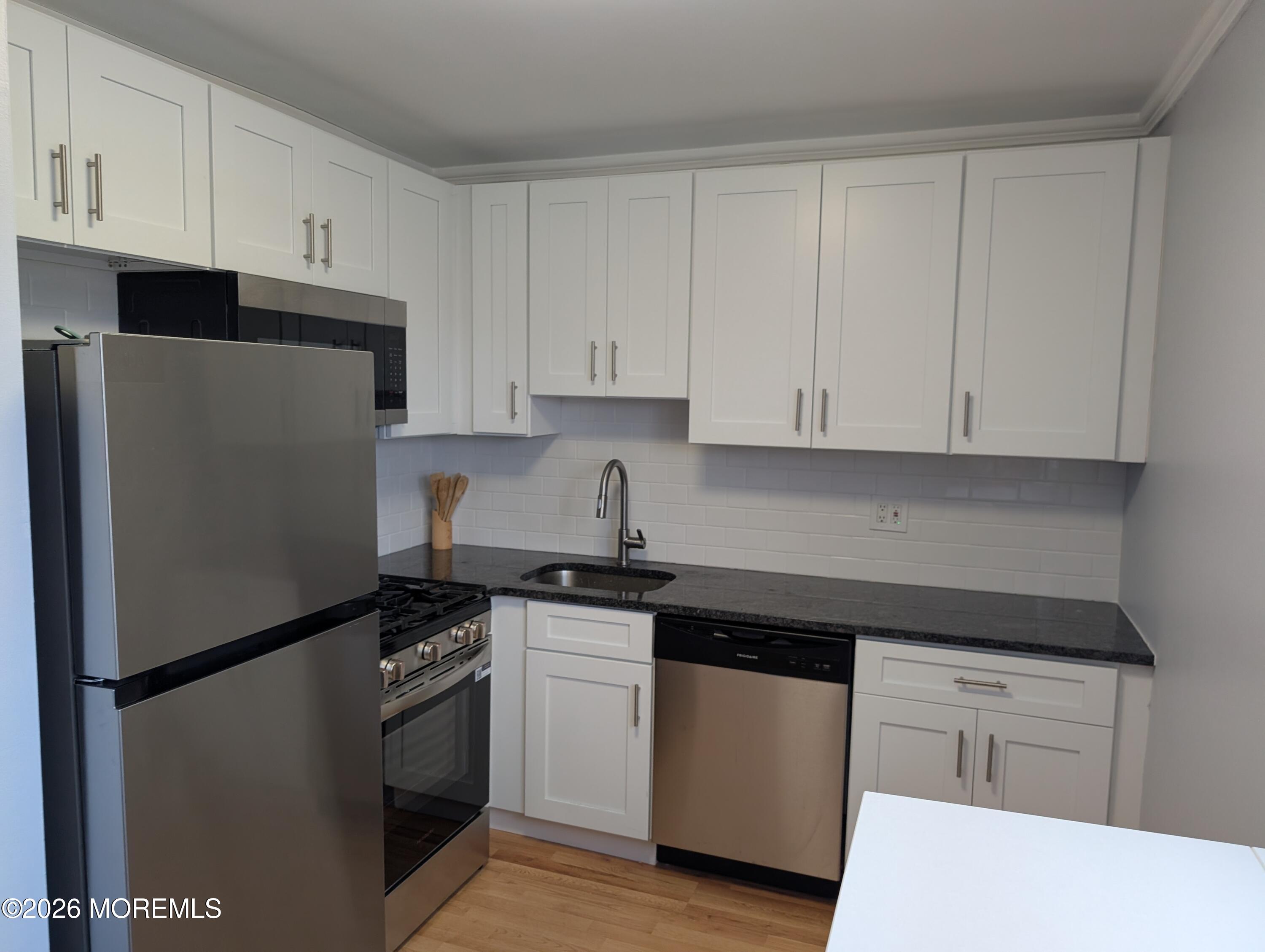 167 Wyckoff Road, Unit B Eatontown, NJ 07724 - Photo 1 of 15 a kitchen with white cabinets and refrigerator