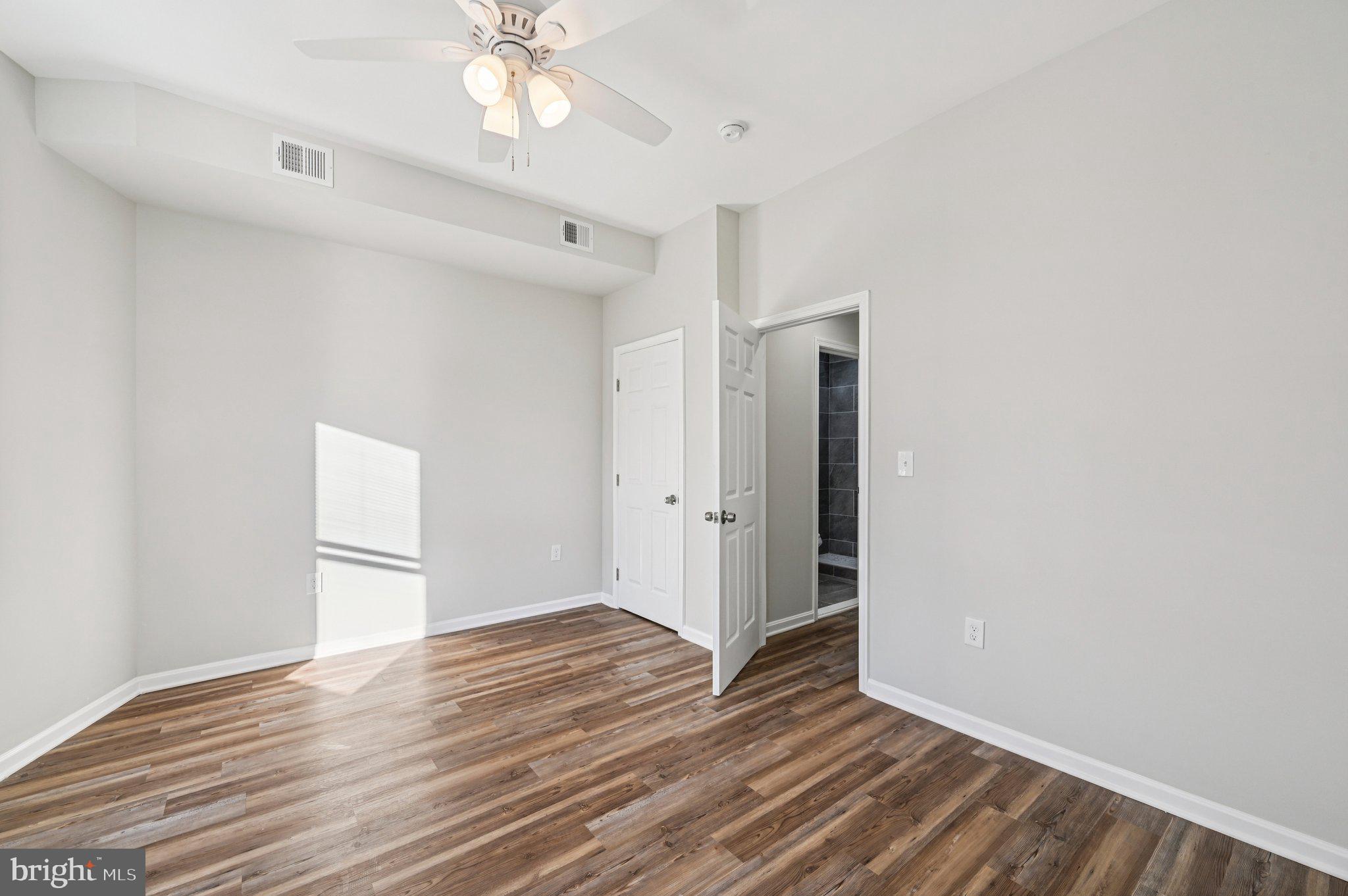 750 Reservoir Street, Unit B Baltimore, MD 21217 - Photo 22 of 25 a view of an empty room with wooden floor and a ceiling fan