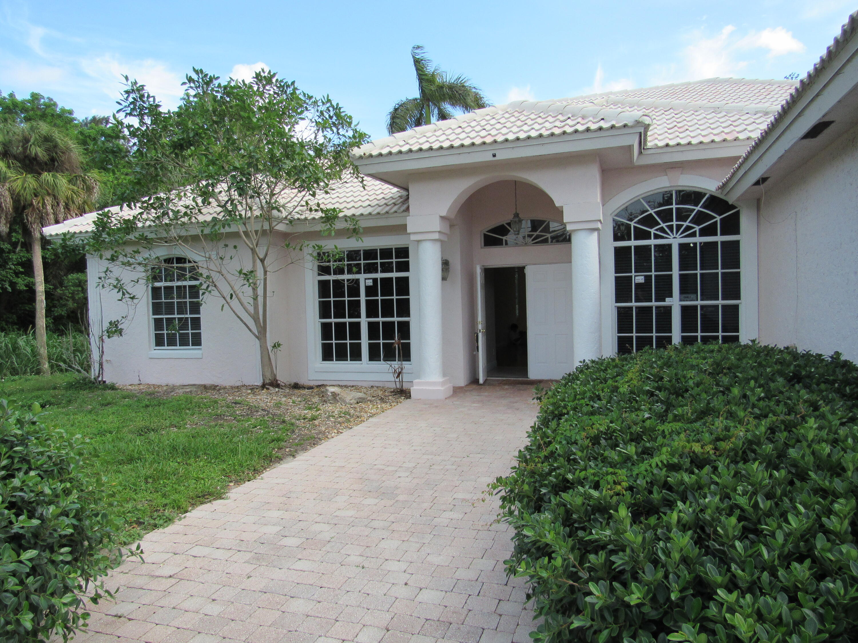 a view of a white house next to a yard