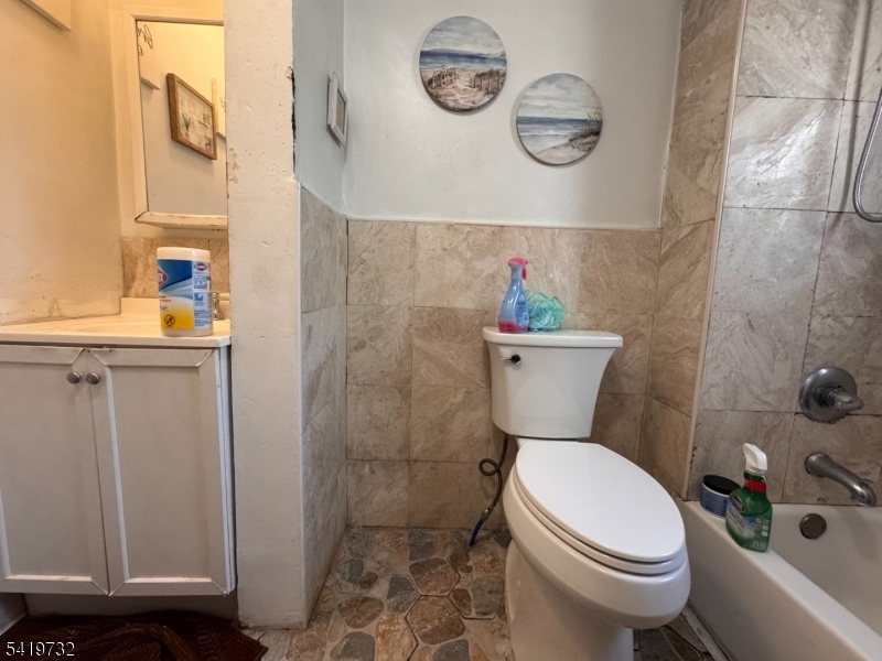 321 South 5th Street Elizabeth, NJ 07202 - Photo 6 of 10 a white toilet sitting next to a bathroom sink and vanity