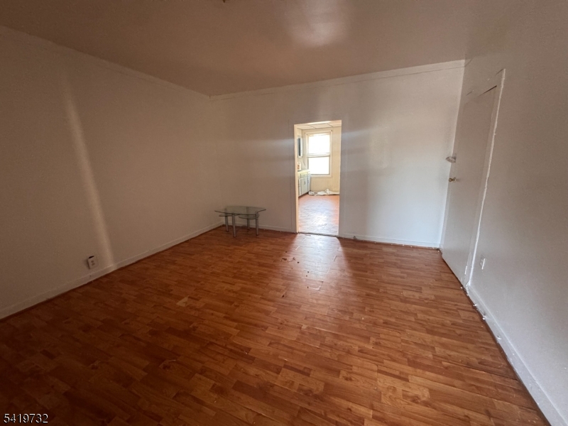 321 South 5th Street Elizabeth, NJ 07202 - Photo 9 of 10 an empty room with wooden floor and windows