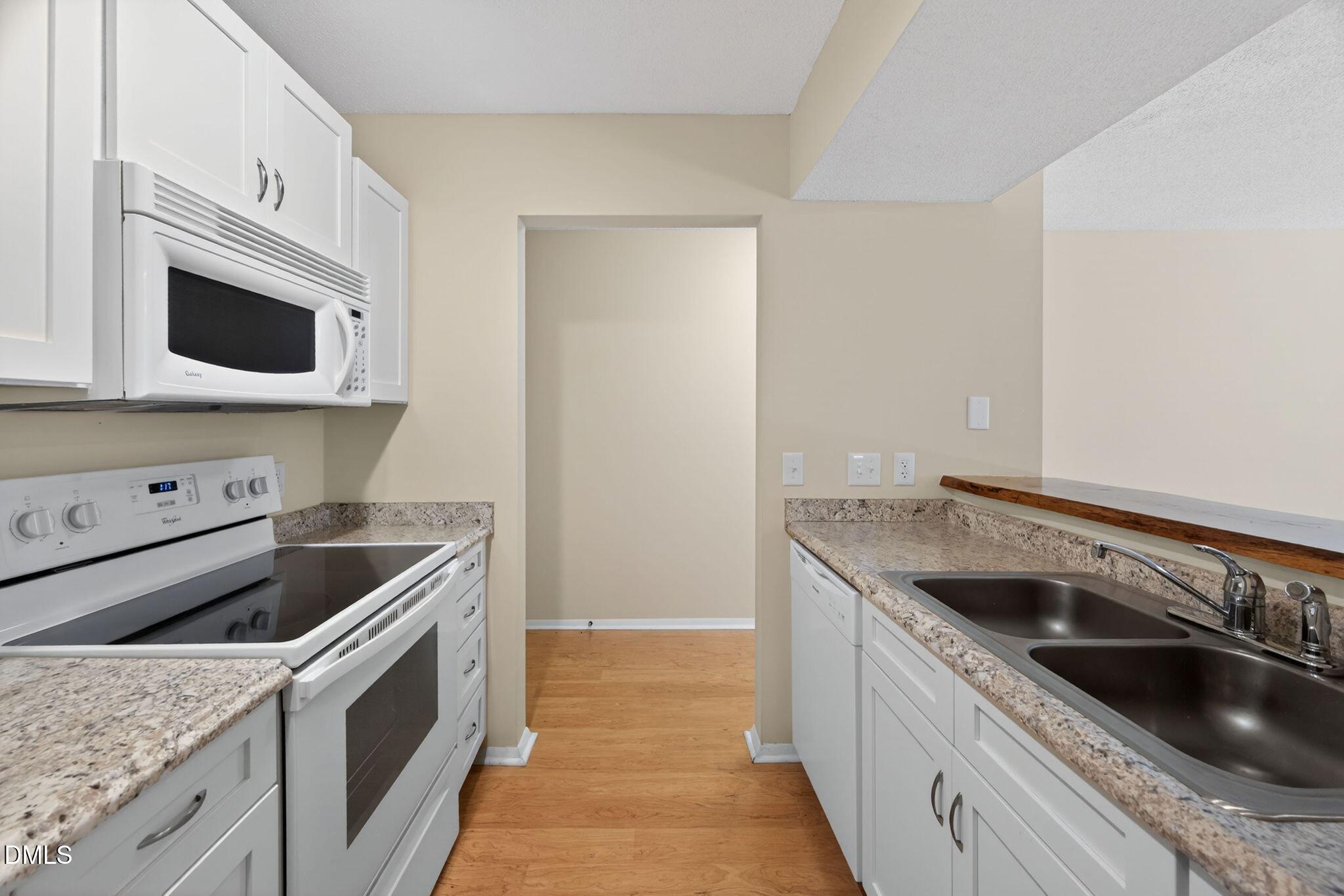 3704 Chimney Ridge Place, Unit 207 Durham, NC 27713 - Photo 6 of 31 a kitchen with granite countertop a sink and a stove top oven