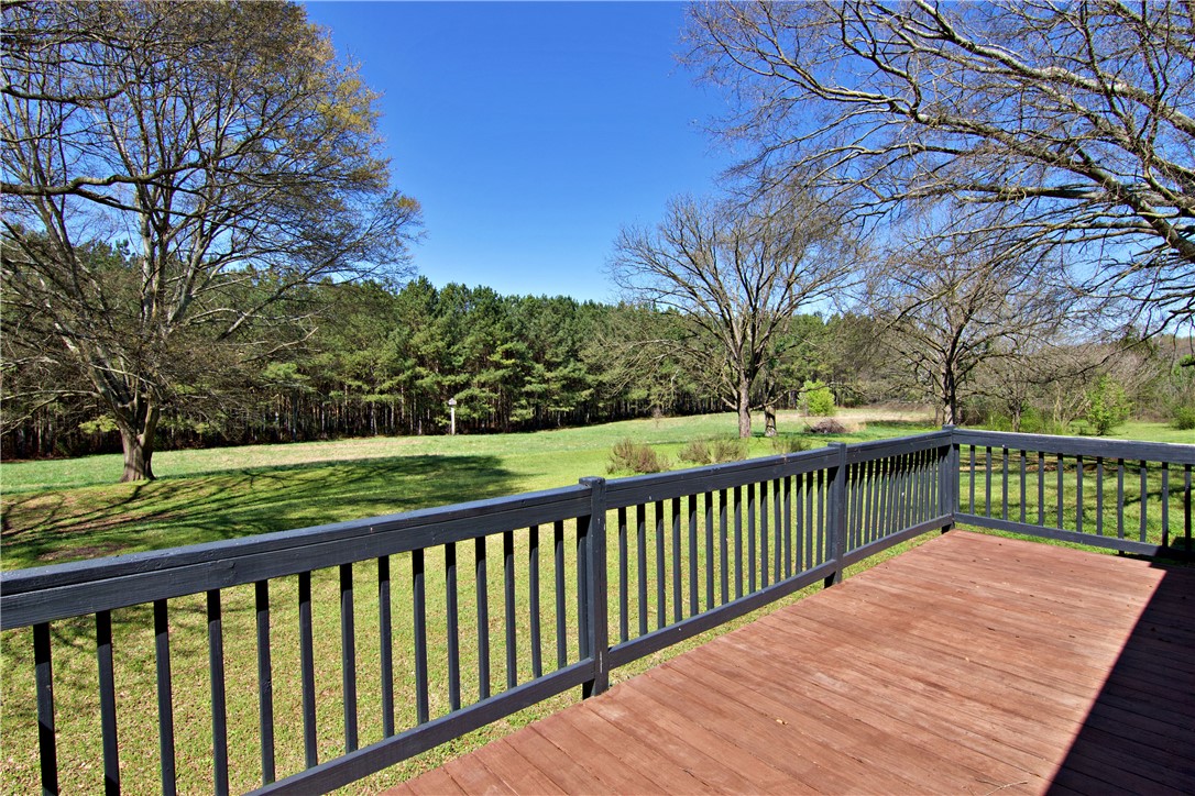7893 Athens Road Carnesville, GA 30521 - Photo 35 of 50 This spacious wooden deck overlooks a verdant landscape, perfect for serene outdoor living.