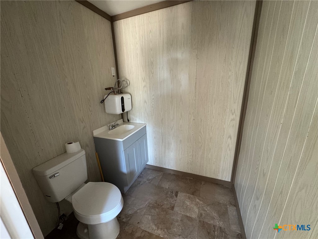 2802 West 4th Street Cameron, TX 76520 - Photo 7 of 12 a bathroom with a toilet sink and mirror