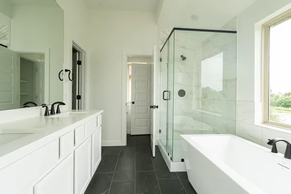 a bathroom with a tub sink shower and mirror
