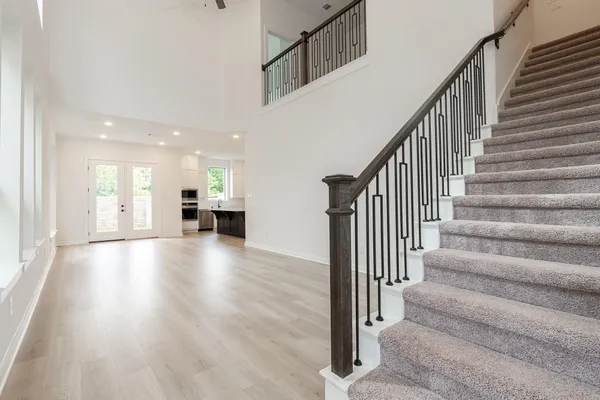 a view of a hallway with wooden floor and staircase