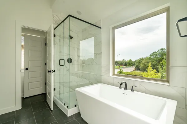 a bathroom with a white tub a shower and a sink