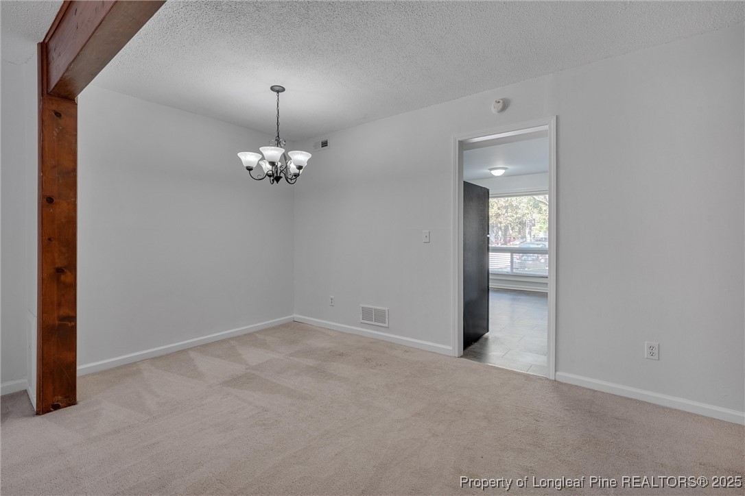 1304 Seaton Road, Unit 17 Durham, NC 27713 - Photo 11 of 32 en empty room with windows and chandelier