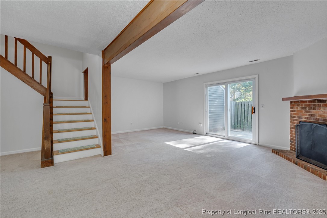1304 Seaton Road, Unit 17 Durham, NC 27713 - Photo 12 of 32 a view of empty room with stairs and fireplace