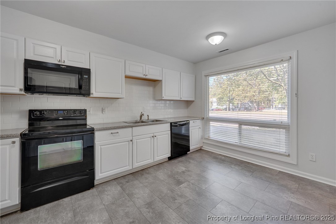 1304 Seaton Road, Unit 17 Durham, NC 27713 - Photo 6 of 32 a kitchen with stainless steel appliances granite countertop a stove a sink and a microwave