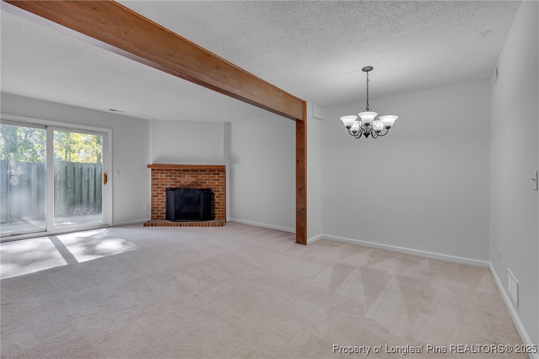 1304 Seaton Road, Unit 17 Durham, NC 27713 - Photo 10 of 32 an empty room with chandelier fan and fireplace