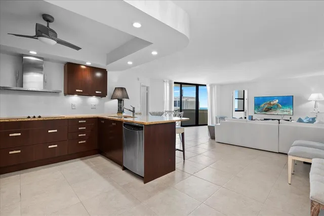 a large living room with stainless steel appliances kitchen island granite countertop a couch and a view of living room