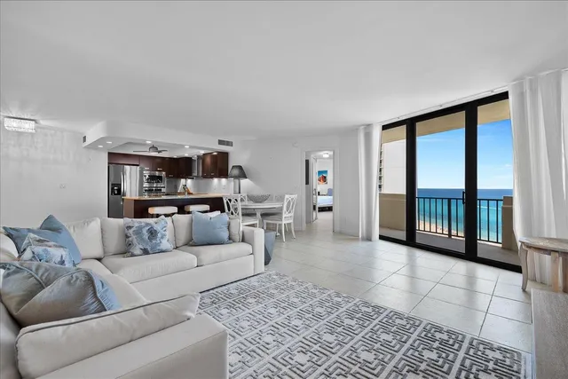 a living room with furniture or large window and kitchen view