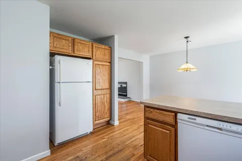 a kitchen with a refrigerator and a wooden floor
