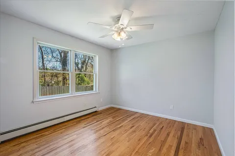 wooden floor in an empty room with a window