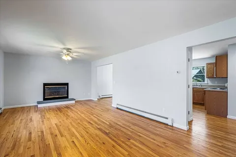 a view of empty room with wooden floor
