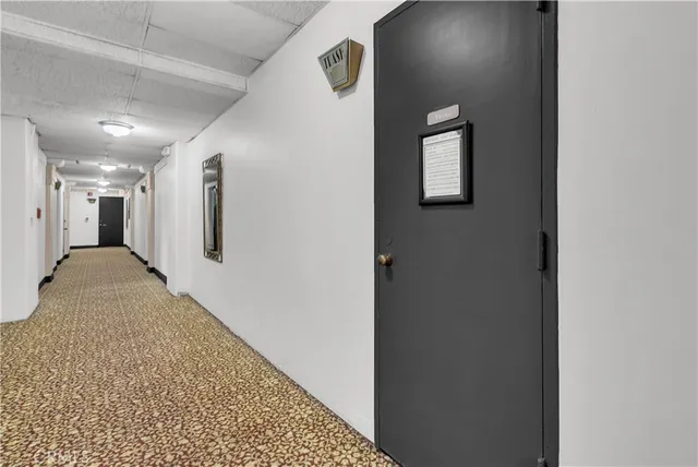 a view of a hallway with wooden floor and a bathroom