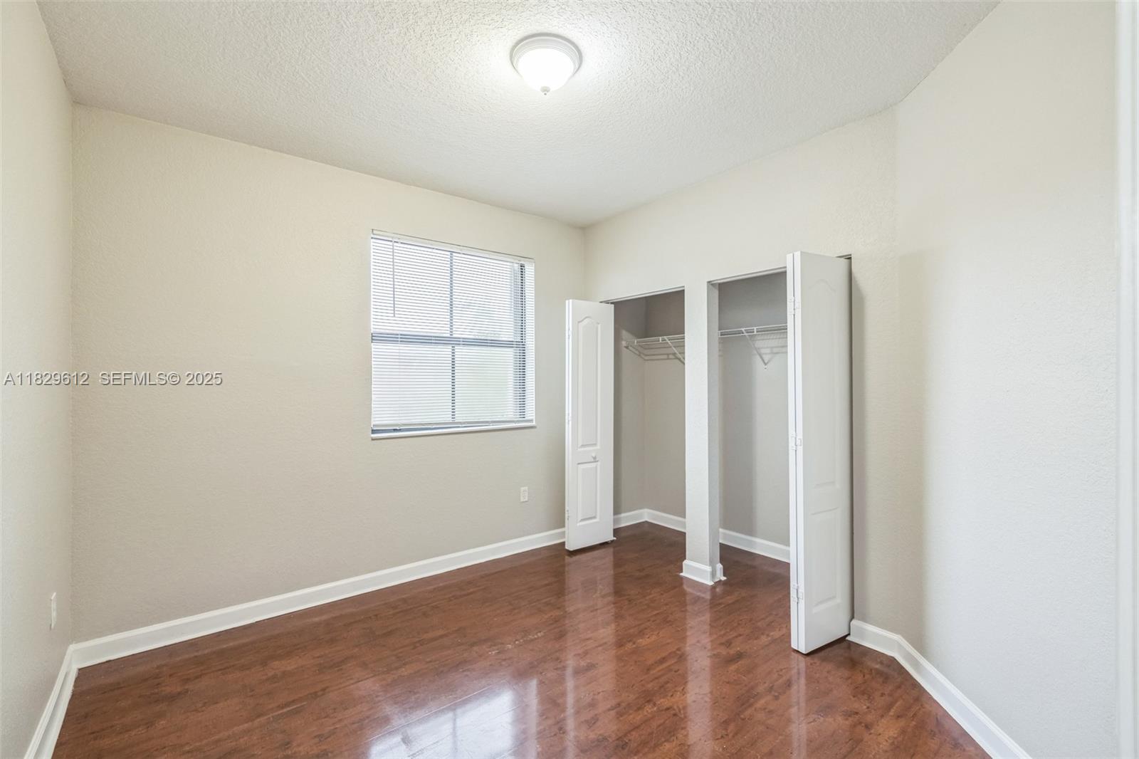 11266 Southwest 236 Lane Homestead, FL 33032 - Photo 14 of 32 an empty room with wooden floor and windows