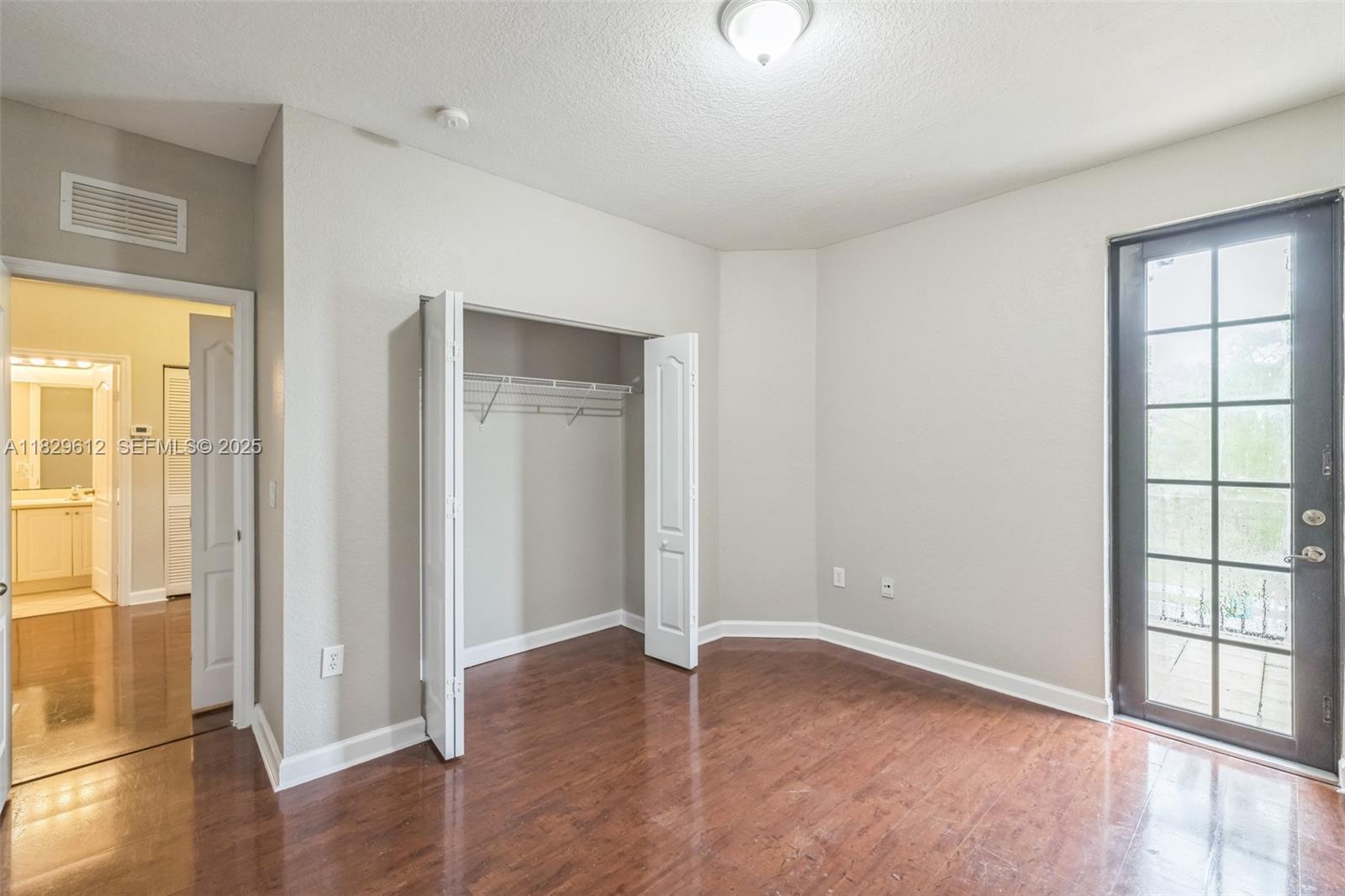11266 Southwest 236 Lane Homestead, FL 33032 - Photo 21 of 32 an empty room with wooden floor and windows