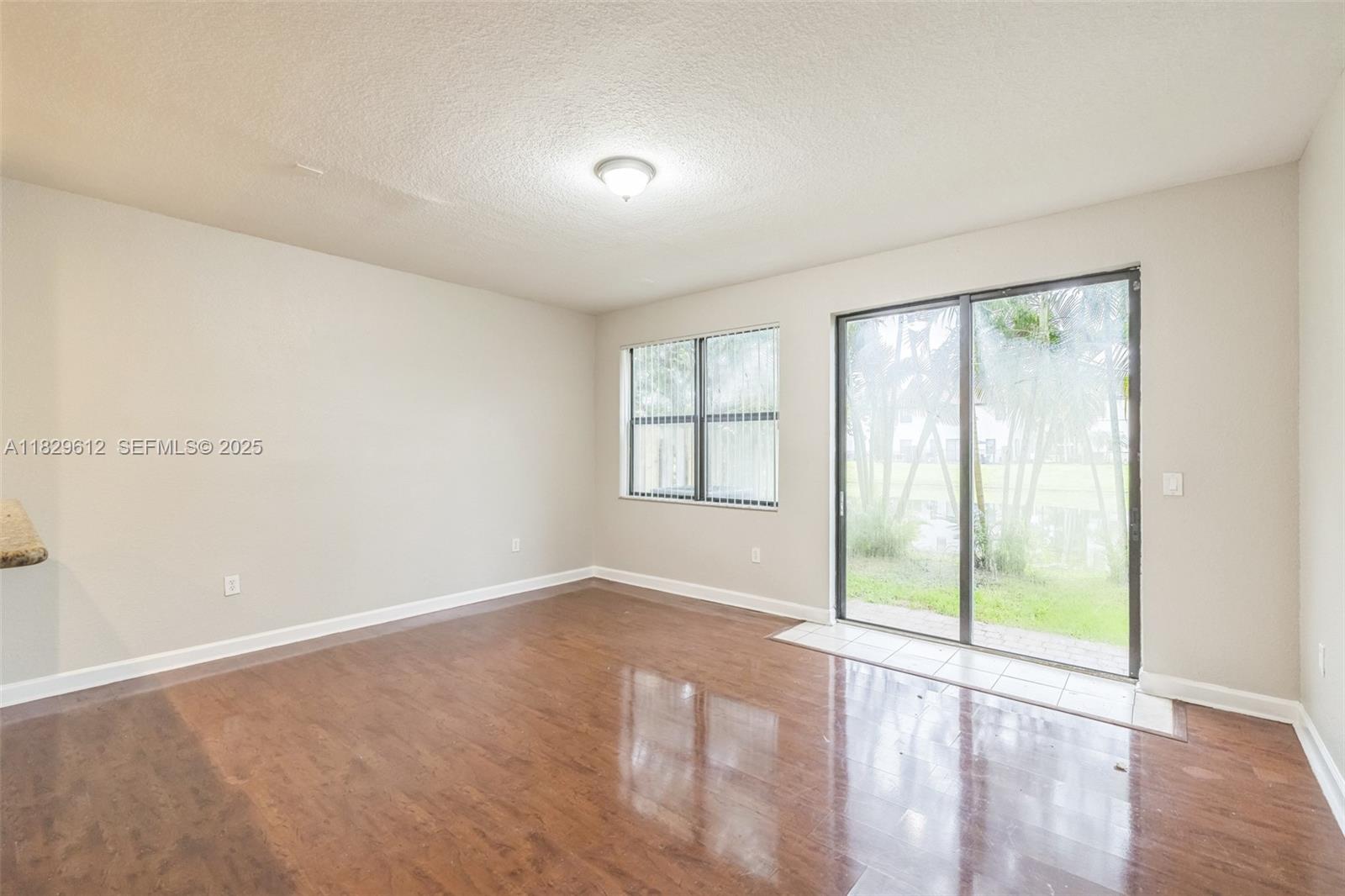 11266 Southwest 236 Lane Homestead, FL 33032 - Photo 25 of 32 an empty room with wooden floor and windows
