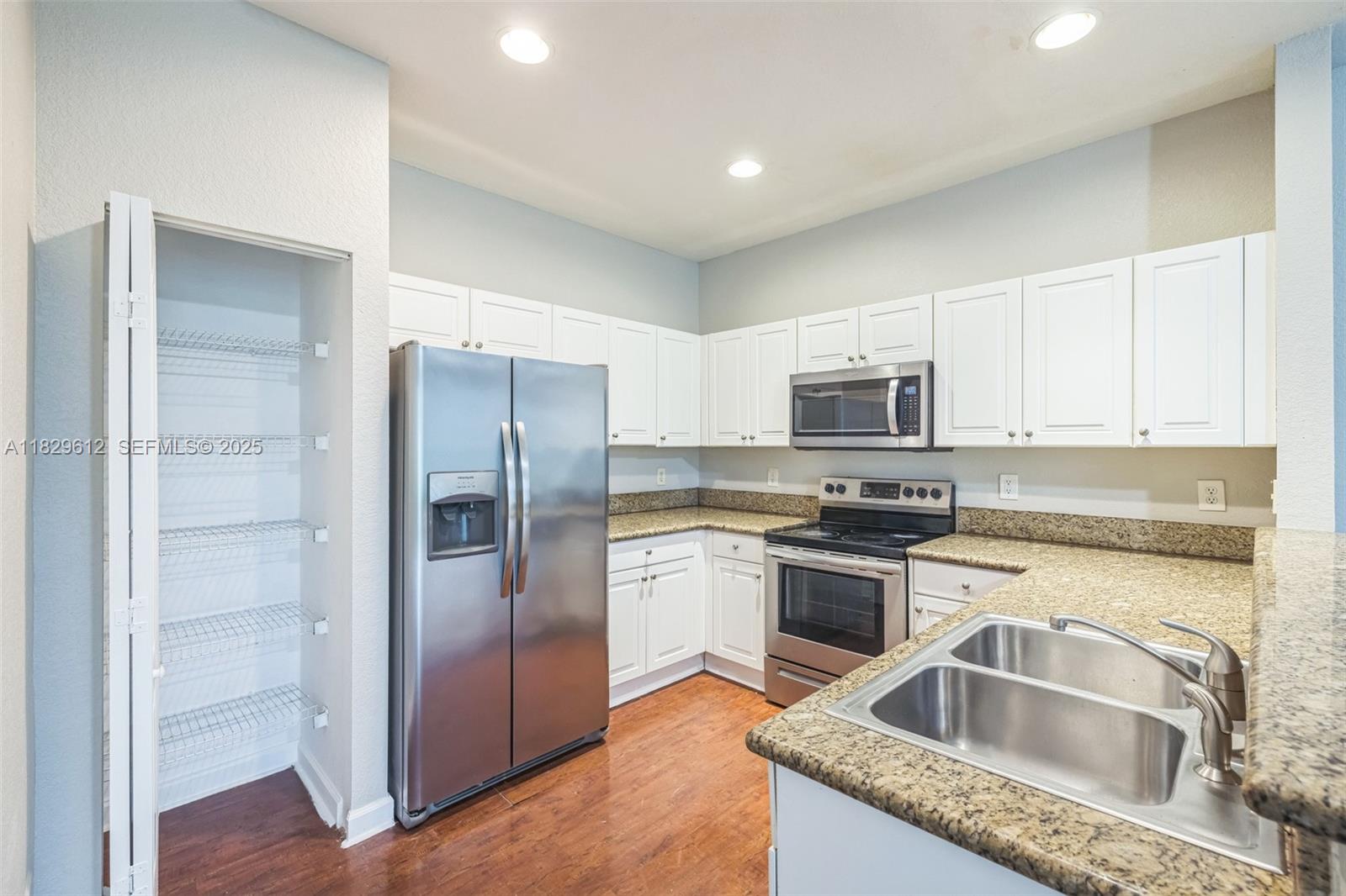 11266 Southwest 236 Lane Homestead, FL 33032 - Photo 28 of 32 a kitchen with granite countertop stainless steel appliances cabinets and a sink