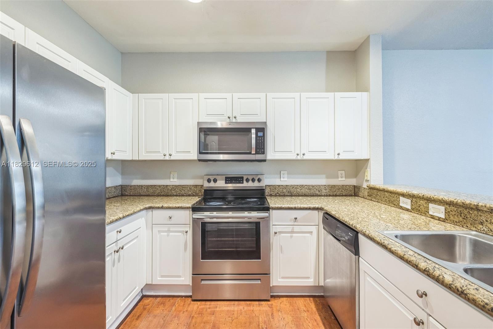 11266 Southwest 236 Lane Homestead, FL 33032 - Photo 29 of 32 a kitchen with white cabinets stainless steel appliances and sink