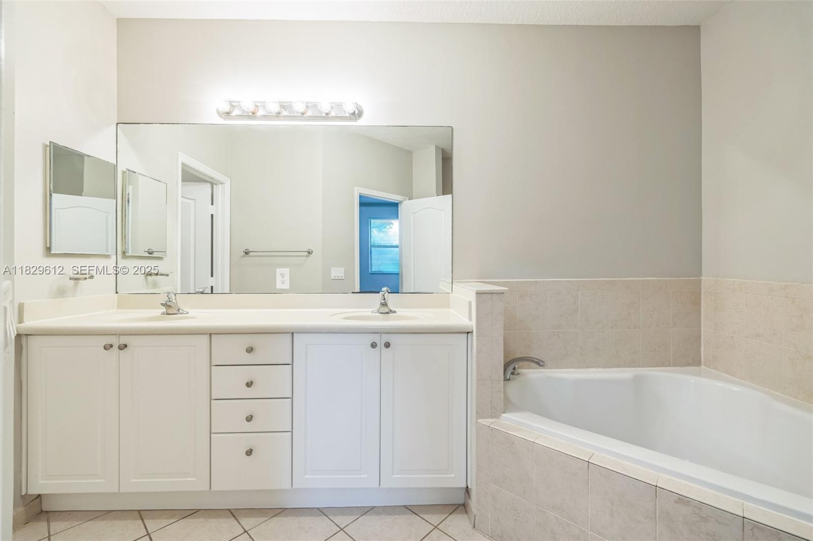 11266 Southwest 236 Lane Homestead, FL 33032 - Photo 7 of 32 a bathroom with a tub a double vanity sink and mirror