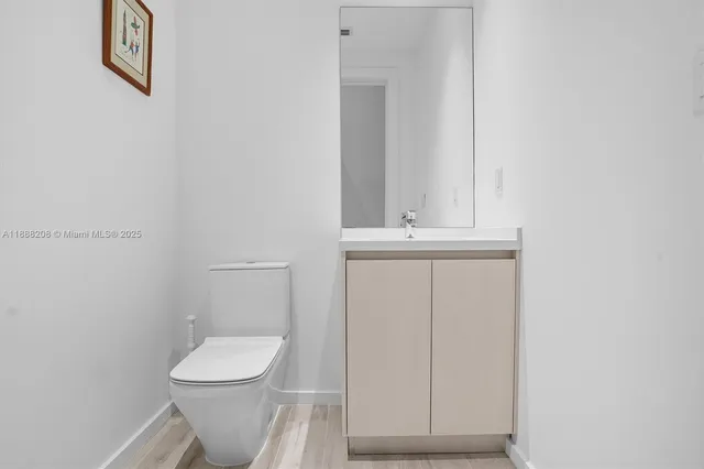 a bathroom with a toilet a sink a vanity and mirror