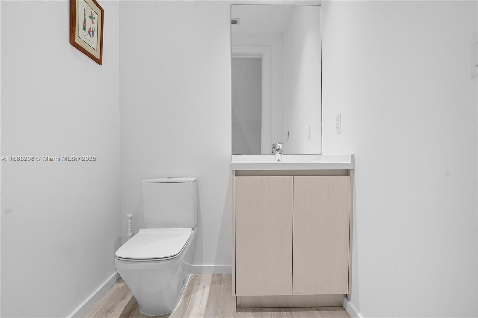 3156 Southwest 27th Avenue, Unit 203 Miami, FL 33133 - Photo 13 of 34 a bathroom with a toilet a sink a vanity and mirror