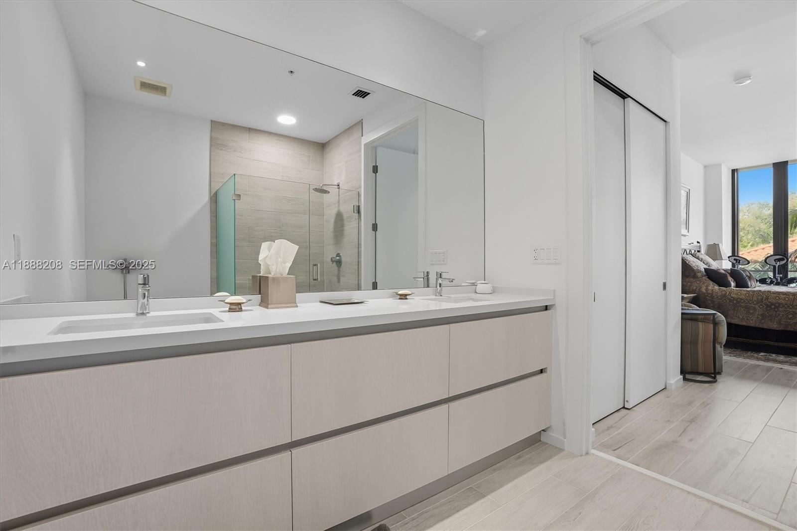 3156 Southwest 27th Avenue, Unit 203 Miami, FL 33133 - Photo 16 of 34 a bathroom with double sink and a mirror