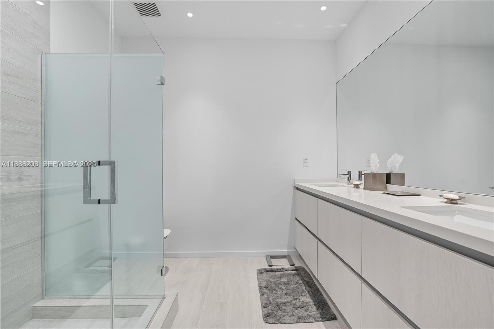 3156 Southwest 27th Avenue, Unit 203 Miami, FL 33133 - Photo 17 of 34 a bathroom with a sink and a mirror