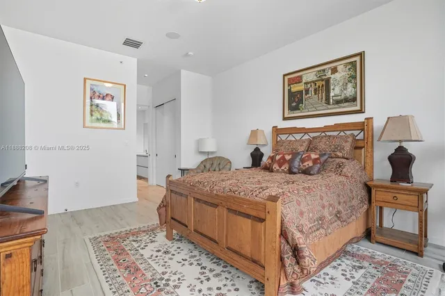 a bedroom with a bed and a lamp on dresser