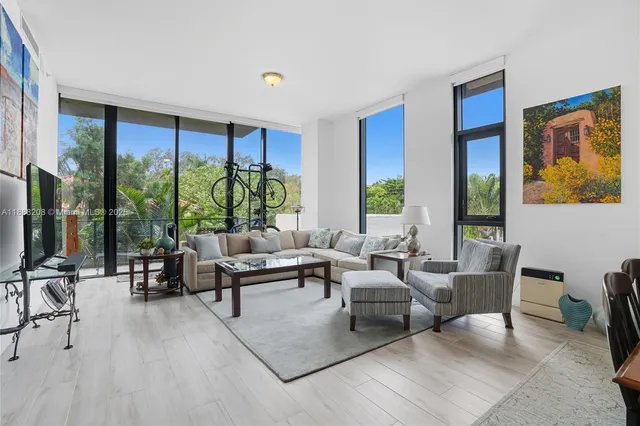 a living room with furniture and large windows