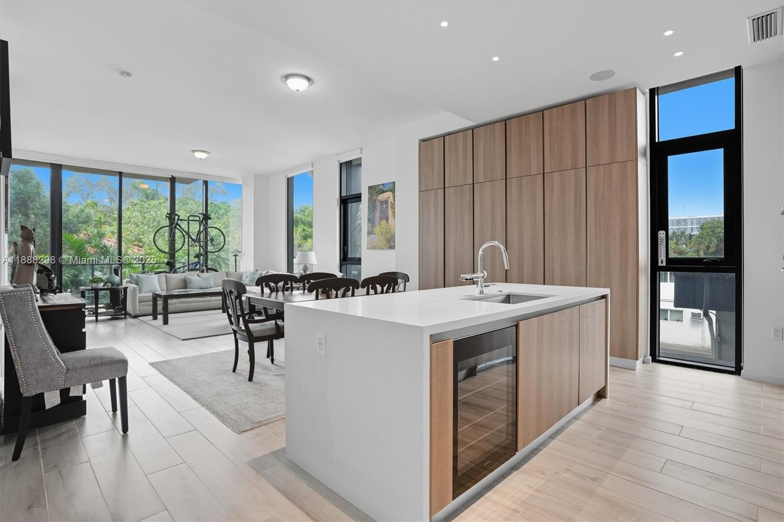 3156 Southwest 27th Avenue, Unit 203 Miami, FL 33133 - Photo 10 of 34 a living room with stainless steel appliances granite countertop furniture a large window and a kitchen view