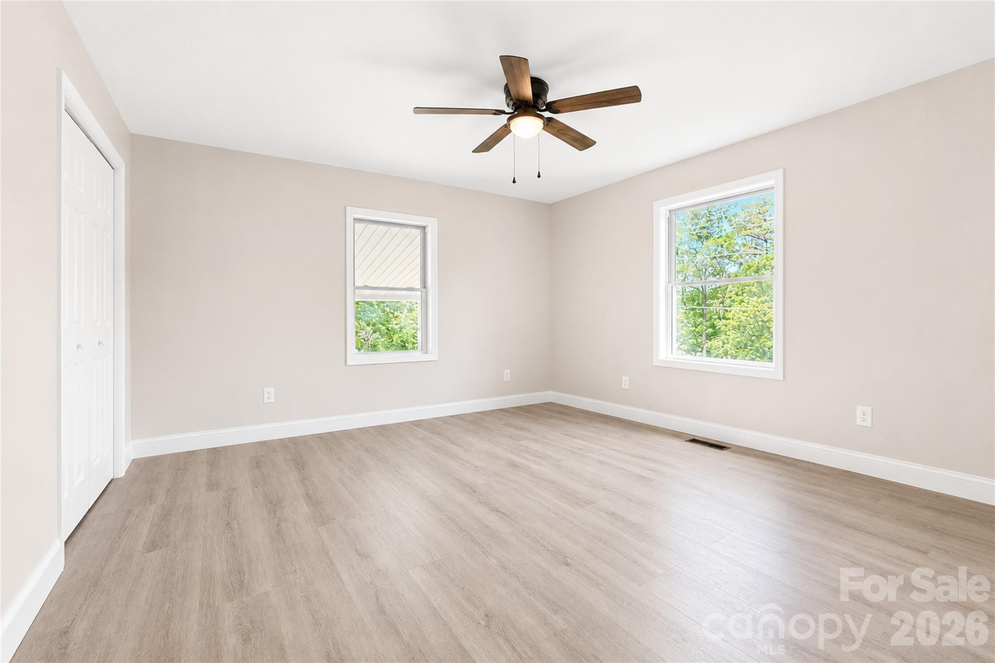1403 Dudley Shoals Road Granite Falls, NC 28630 - Photo 19 of 34 an empty room with wooden floor windows and fan