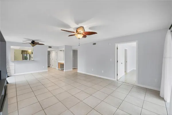 a view of a livingroom with a chandelier fan and kitchen