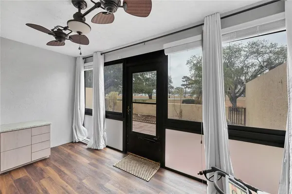 a view of empty room with wooden floor and fan