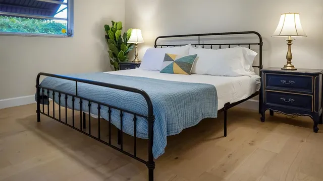 a bedroom with a bed and a lamp on dresser