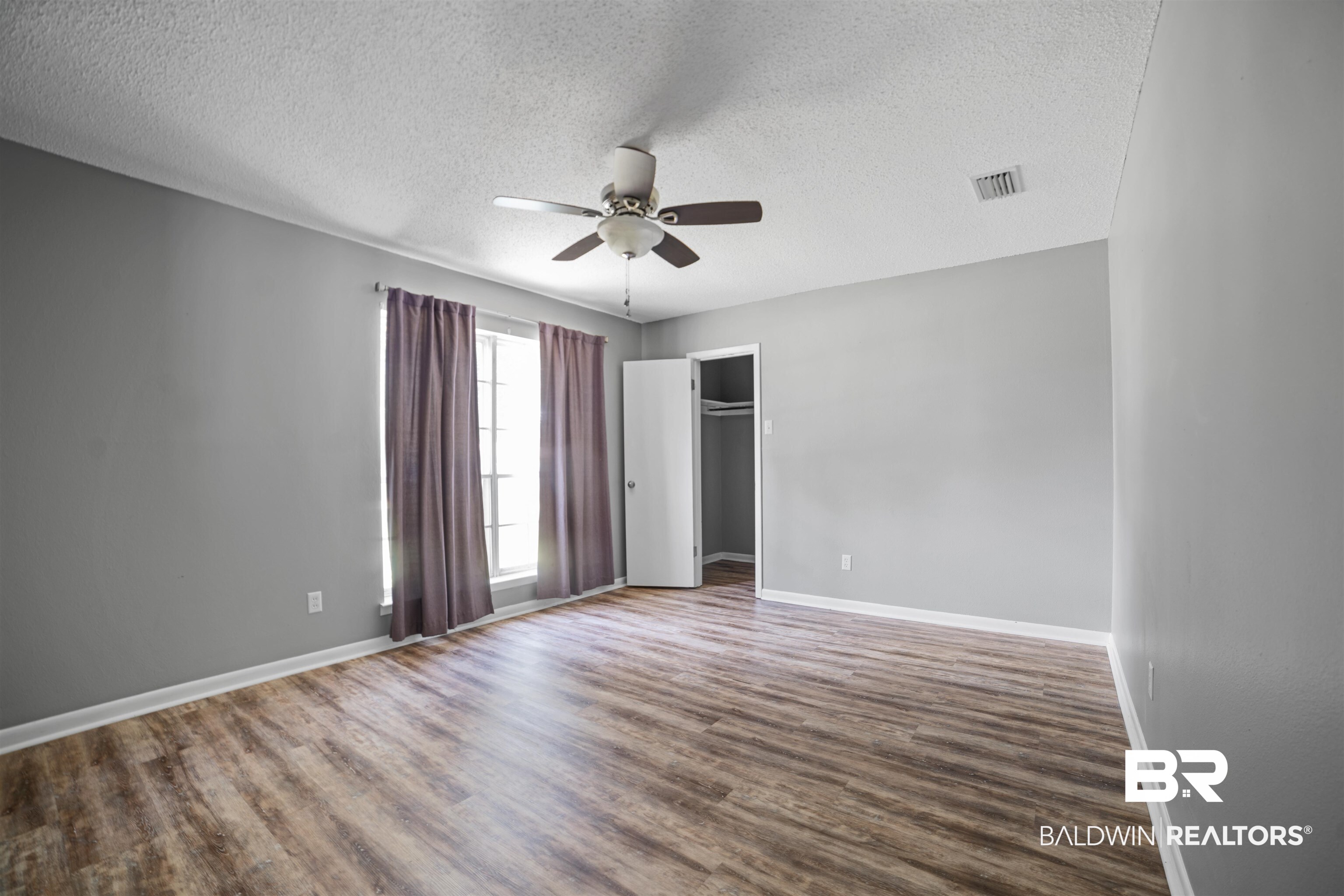 804 Regents Drive West Mobile, AL 36609 - Photo 22 of 35 Unfurnished bedroom with a textured ceiling, wood finished floors, a ceiling fan, and a closet
