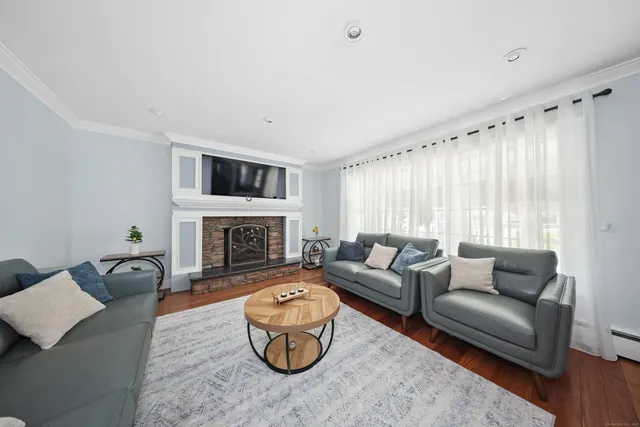 a living room with furniture a fireplace and a flat screen tv