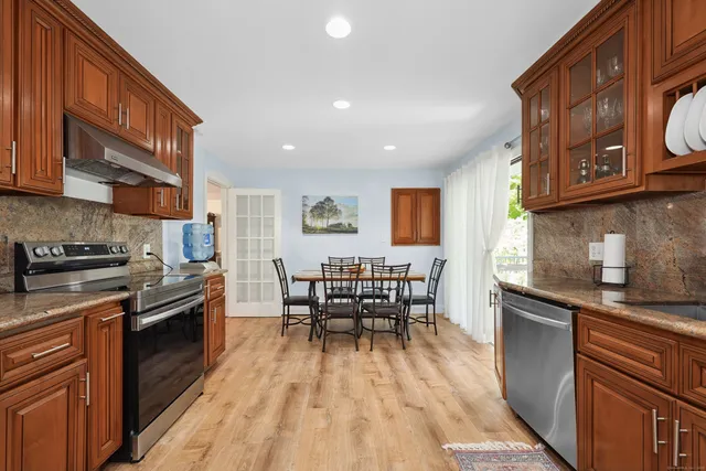 a kitchen with granite countertop a sink stove and cabinets
