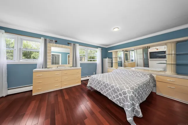 a room with a bed and wooden floor