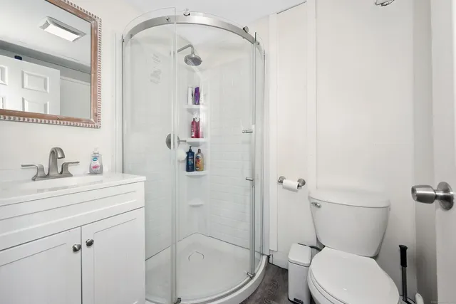 a bathroom with a sink a toilet and shower