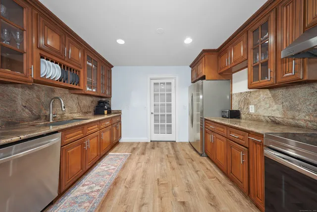 a kitchen with stainless steel appliances granite countertop a sink stove cabinets and wooden floor