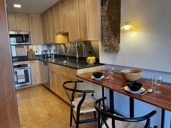 a kitchen with a table chairs sink and cabinets