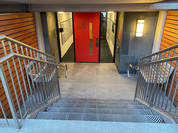 a view of staircase with railing and a rug