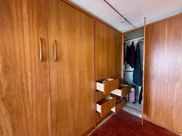 a view of a hallway with wooden floor and furniture