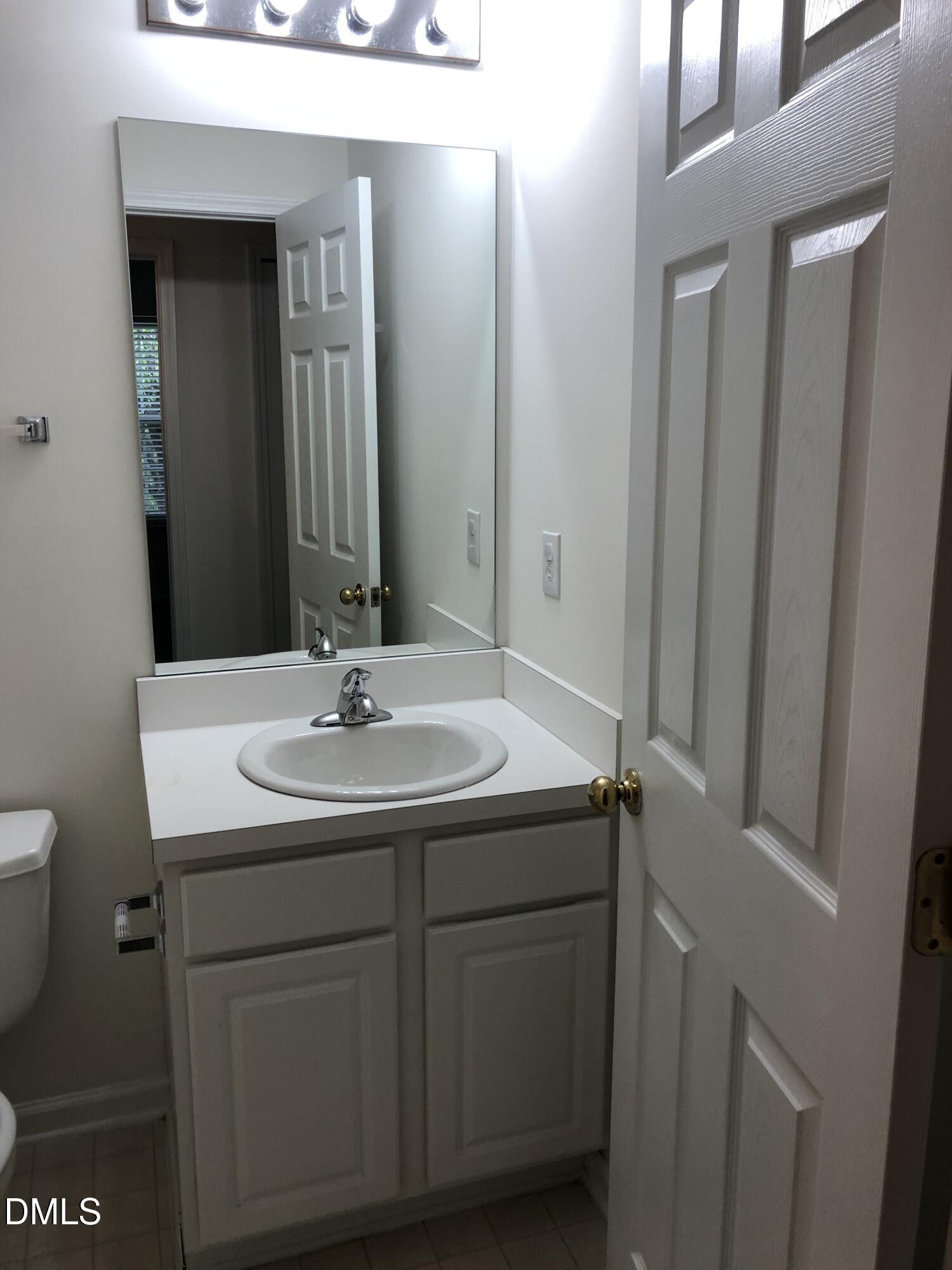 4806 Tapestry Terrace Durham, NC 27713 - Photo 12 of 18 a bathroom with a sink and a mirror
